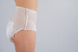 © Михаил Решетников - Side view of a Woman in adult diapers on a white background. Incontinence problem.