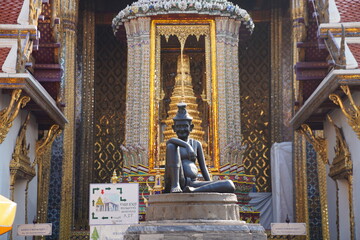 Wall Mural - A spinning hermit statue sitting at the entrance in Wat Phra Kaew, Bangkok, Thailand.