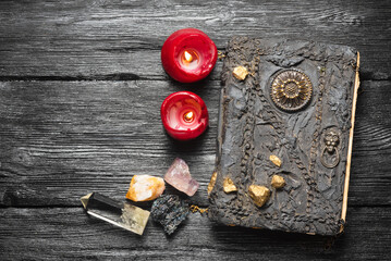 Wall Mural - Old magic book and magical minerals on the wooden table flat lay background with copy space.