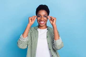 Wall Mural - Portrait of attractive smart clever cheerful girl touching specs isolated over bright blue color background