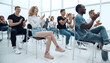 © ASDF - group of young people sitting in a bright conference room.