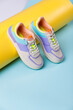 Close up of trendy colored sneakers for teenage girls on colorful yellow-blue background.