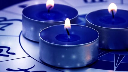 Wall Mural - three blue candles with zodiac and horoscope background with shining falling lights like astrology theme 