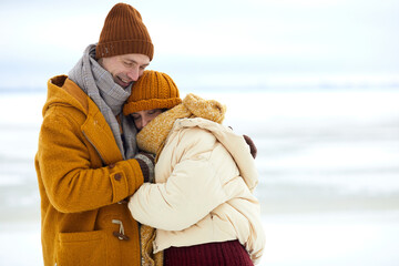 Waist up portrait of loving young couple embracing in minimal winter landscape, copy space