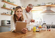© Nina Lawrenson/peopleimages.com - Tablet, baking and retirement with a senior couple cooking in the kitchen of their home together. Food, technology and health with an elderly man and woman following an internet recipe to make a meal