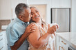 © Beaunitta V W/peopleimages.com - Love, laughing and elderly couple embrace in kitchen, having fun, talking and being silly together. Happy family, relax and retirement by senior man and woman enjoy conversation and relaxed lifestyle