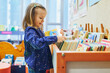 © Ekaterina Pokrovsky - 4 year old girl selecting a book in municipal library