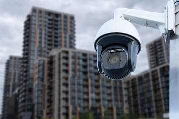 Wall Mural - Panoramic view of CCTV surveillance camera with blurred apartment building background with copy space for background banner.