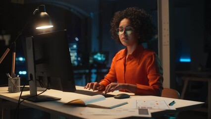 Fototapete - Young Black Female Working on Desktop Computer in Creative Office in the Evening. Happy Multiethnic Project Manager Writing Emails, Researching Project Plan Details Online.