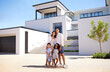 © Beaunitta Van Wyk/peopleimages.com - Portrait, real estate and happy family moving into their new luxury home, house or property in summer. Happy parents and children standing with a smile outdoor with building investment or purchase