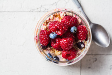 Wall Mural - Overnight oatmeal with berry, peanut butter and maple syrup in jar. Healthy breakfast concept.