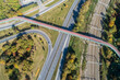 © nahlik - Footbridge with cycle path and pedestrian walkway over a city highway and railway in Krakow, Poland. Aerial view from above