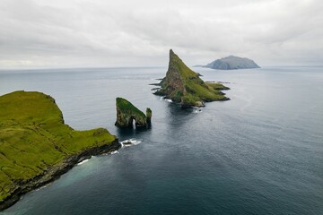 Poster - Scenic view of Drangarnir, Tindholmur, and Mykines islets in the Faroe Islands surrounded by the sea