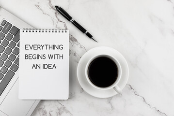 Cup of coffee and note pad with text Everything begins with an idea