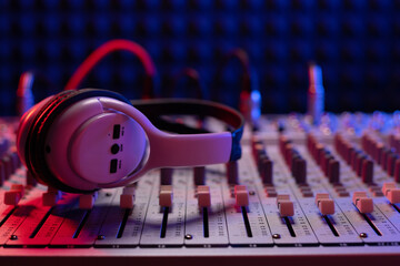 Headphones on sound mixer with faders and music cable jack. Audio equipment in record studio