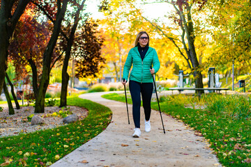 Nordic walking - woman training in city park 