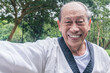 An active elderly man doing Taekwondo at a park