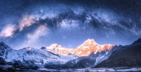 Wall Mural - milky way arch over snowy mountains at starry night in winter. landscape with snow covered high rock
