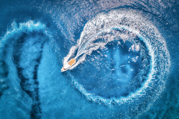 Wall Mural - aerial view of the speed boat in transparent blue water at sunset in summer. top view from drone of 