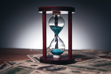 Wall Mural - time is money concept, US dollar banknotes and hourglass as a business banner