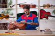 © Elnur - Young man repairing musical instruments at workshop