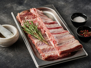 Wall Mural - Raw pork ribs with spices, salt, pepper and rosemary. Fresh pork. Pig ribs.