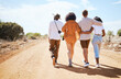 Friends, walking and travel with young people in nature on a sand road with a beautiful desert view of the sky. Vacation, summer and walk with a man and woman group outdoor for a trip or holiday