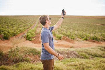 Nature, phone and a man with lost signal in field on farm road trip. Travel, view and vineyard, young traveler with smartphone in agriculture. Gps, wifi or 5g network search on mobile in grass field.