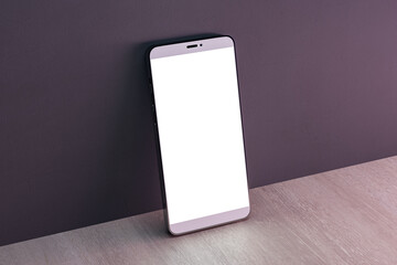 Close up of empty white cellphone on dark wall and wooden surface background. Mobile app concept. 3D Rendering.
