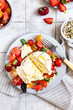 Salad with burrata cheese, cherry tomatoes and strawberry with microgreen and olive oil. Traditional Italian burrata cheese. Healthy eating concept. Keto diet.