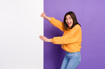 Wall Mural - Photo of astonished overjoyed lady hand hold empty space placard information news black friday advert isolated on purple color background