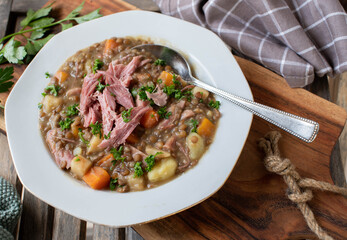 Plate with fresh cooked lentil stew with pork meat, vegetables and potatoes