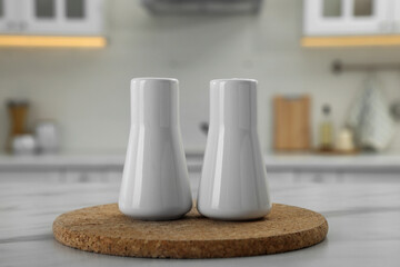 Poster - Ceramic salt and pepper shakers on white marble table in kitchen