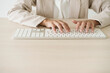 © Westend61 - Close-up of businesswoman typing on keyboard at desk