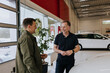 © Johnér - Salesman talking to customer in car dealership
