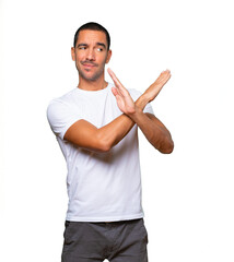 Young man making a gesture of not crossing with the arms