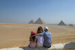 Dreikopfige Familie schaut sich die Pyramiden von Gizeh an. Ansicht von hinten Mädchen, Mutter und Vater. 