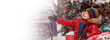 Child in red winter outerwear outdoors in snow showing hand right. New Year Christmas holiday. New year tree and presents background. Wide banner. Copy space, mock up template
