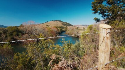 Wall Mural - Private property and river. Clean river flows in Brazilian highlands, camera moves back and reveals the fence on private property