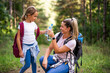 © inesbazdar - Mother and daughter drinking water and enjoy hiking together.