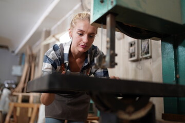 Contemporary Carpenter Working, Portrait of modern carpenter making wood furniture while working in joinery lit by sunlight with factory background on small business concept, copy space