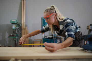 Contemporary Carpenter Working, Portrait of modern carpenter making wood furniture while working in joinery lit by sunlight with factory background on small business concept, copy space