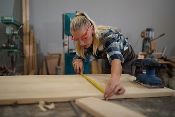 Contemporary Carpenter Working, Portrait of modern carpenter making wood furniture while working in joinery lit by sunlight with factory background on small business concept, copy space