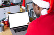 © wavebreak3 - African american man wearing santa hat, using laptop with copyspace