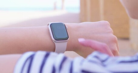 Woman using her smartwatch touchscreen with greenscreen. 
