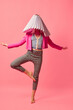 Weird people concept. Creative portrait of young girl in avant-garde style image isolated over pink background. Vivid style, queer, art, fashion