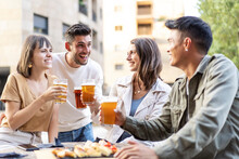 Multiracial Friends Drinking Beer At Brewery Pub Garden - Genuine Friendship Life Style Concept With Guys And Girls Enjoying Happy Hour Food Together At Open Air Bar Dehor - Warm Vivid Filter