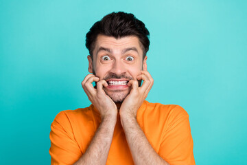 Canvas Print - Closeup photo of young handsome attractive bearded man wear stylish orange t-shirt gnaw bite nails nervous isolated on aquamarine color background