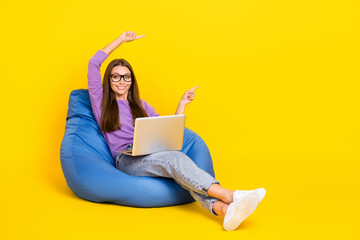 Sticker - Photo of positive lady sit chair two arm above head direct empty space recommend modern device shop isolated on yellow color background