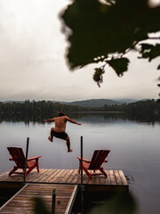 Wall Mural - Lake with wooden platform and men jumping in the water